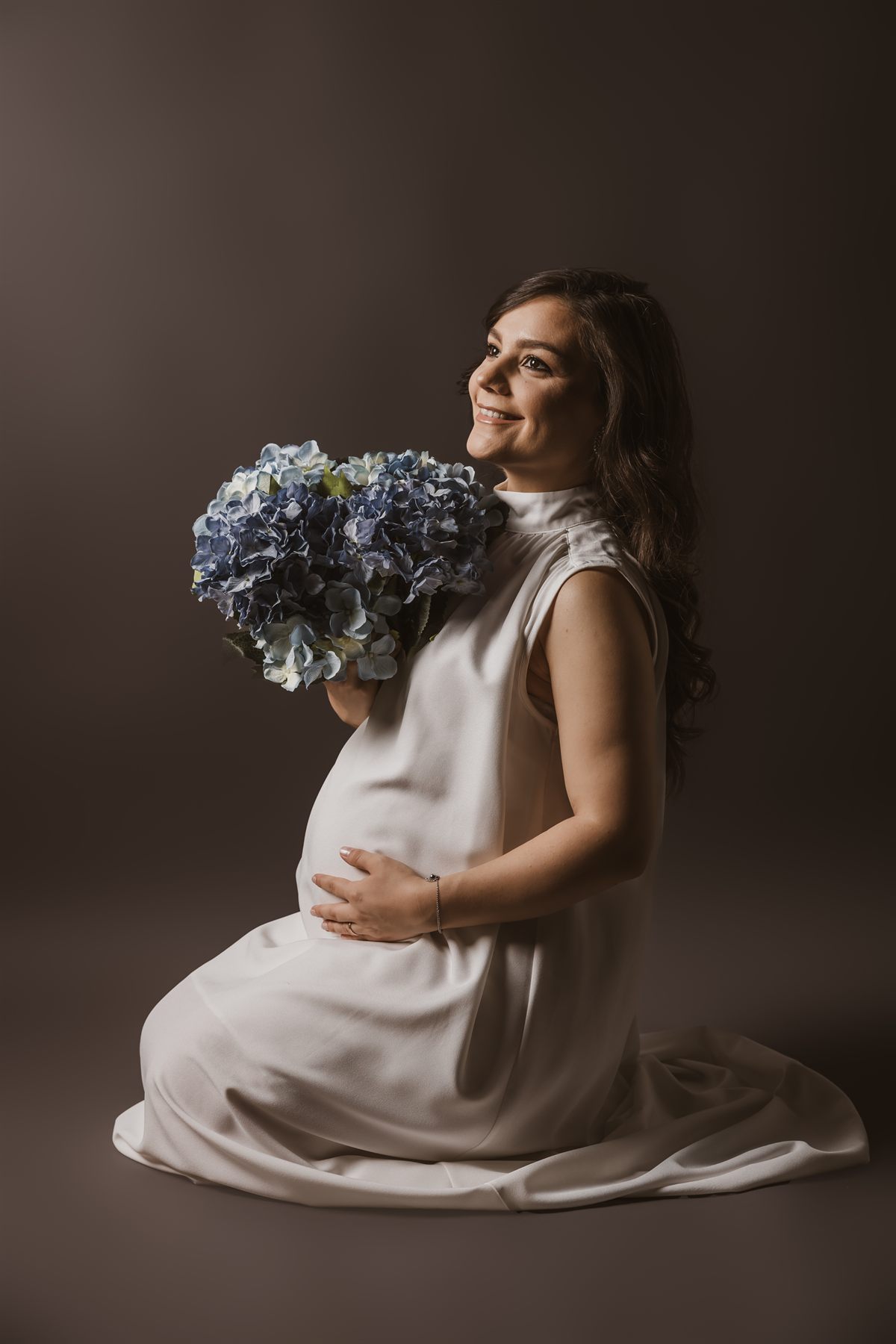 Viitoare mamă ținându-și burtica, lumină de studio — ședință foto maternitate, Oradea (15)